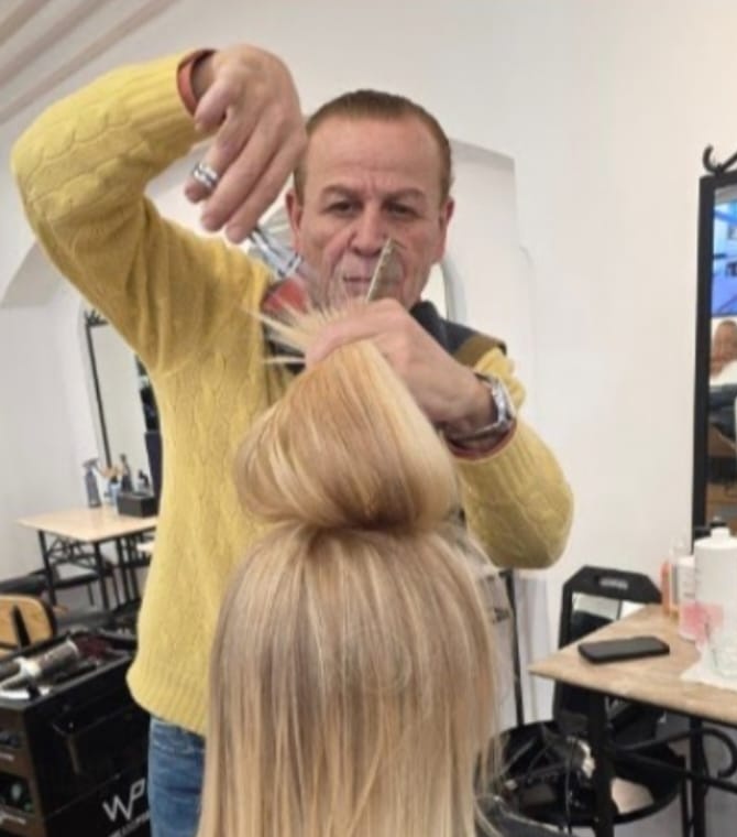 A stylist at work beside an arched mirror